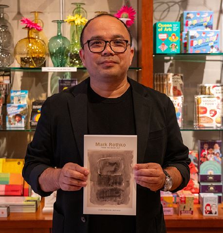 Priyananda holding up a book in the shop